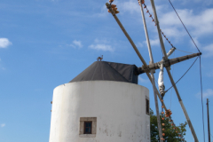 Cylindrical shaped blue and white windmill with a conical roof on hilltop Portugal