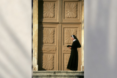 Nun by large wooden door